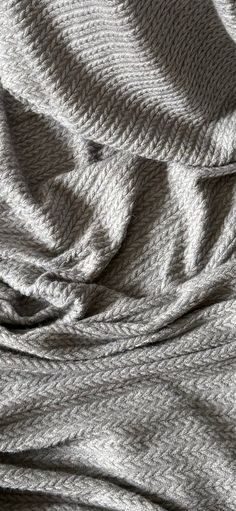 an image of a blanket that has been made into a bed spread with grey and white stripes on it