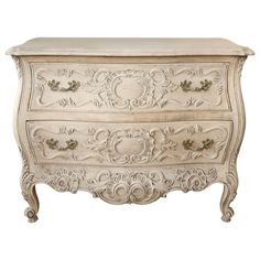 an ornate white dresser with drawers