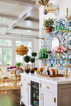 a kitchen with blue and white tiles on the wall, potted plants in vases