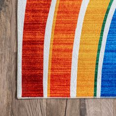 a multicolored rug on a wooden floor with wood floors and planks in the background