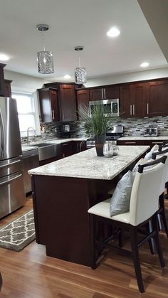 a large kitchen with wooden floors and stainless steel appliances