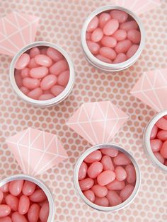 four small tins filled with pink candy