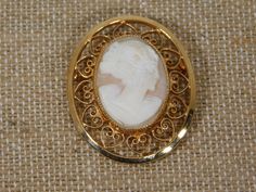 Carved cameo brooch in oval frame with open hearts work 1/20 12 K  G F.  Brooch is in excellent condition. Not sure what the material is don't know it it's shell or not the back is dull not shiny and light pinkish color. Collectible Oval Cameo Brooch, Collectible Oval Cameo Brooches, Oval Cameo Brooch For Anniversary, Cameo Brooch, Oval Frame, Open Heart, Brooch Pin, Brooches, Shells