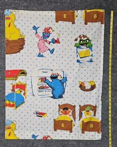 a child's bed with sesame the cat and other cartoon characters on it, next to a measuring tape