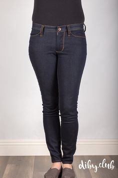 a woman in black shirt and jeans standing on wooden floor