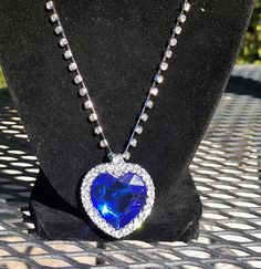 The famous blue heart of the ocean necklace. Beautiful sparkle, created gemstones are  properly faceted to capture and reflect the light.  measures 20 inches plus a 2 inch extender is included. Blue Round Pendant Necklace For Party, Heart Shaped Crystal Gemstone Jewelry, Heart Cut Crystal Necklace For Party, Blue Jewelry For Valentine's Day Party, Heart-shaped Crystal Jewelry With Jewels, Sapphire Heart Pendant With Heart Charm, Blue Heart Pendant Jewelry For Party, Blue Heart Cut Jewelry For Party, Blue Heart Necklaces For Party