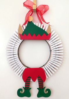 a paper plate wreath with an elf's hat on top