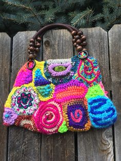 a multicolored crocheted purse sitting on top of a wooden table