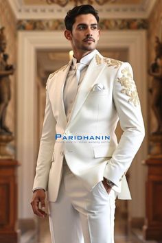 =>UNIQUE CREATION - PLEASE RESPECT COPYRIGHT<= All images and content on this site are exclusively crafted and owned by Paridhanin. Unauthorized copying, sharing, or reproduction is prohibited and will be subject to legal action. This stunning white suit features luxurious gold embroidery on the shoulders and cuffs, providing an elegant and refined look. Made from premium fabric, it offers a tailored fit that exudes sophistication. Perfect for grooms seeking a classic yet contemporary style for weddings or formal events, ensuring a memorable appearance. The price includes Jacket and pant only. Other accessories if you want like shirt , tie and pocket square will be available on extra cost. For this message us in personalisation box. The suit is meticulously crafted from a luxurious  polyes White And Gold Tuxedo Groom Suits, Ivory Wedding Tuxedo For Men, Off White Wedding Suit For Men, White Suit With Gold Accents, White And Gold Tuxedo Wedding, White And Gold Suit Men, Gold Naqshi Sets For Wedding, Elegant Gold Unstitched Suit For Wedding, Elegant Gold Unstitched Wedding Suit