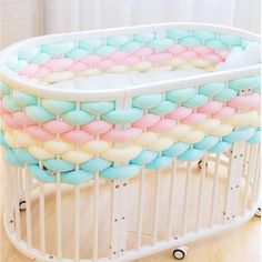 a baby crib with pastel colors in it