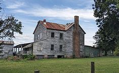 an old house sitting on top of a lush green field