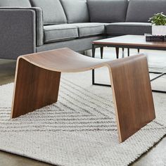 a modern living room with grey couches and coffee table in the middle, along with a rug on the floor