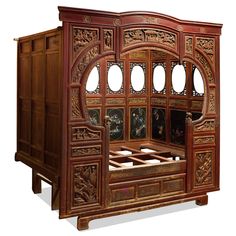 an ornately carved wooden bed frame with glass doors on the front and side panels