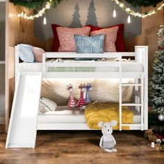 a white bunk bed sitting next to a christmas tree