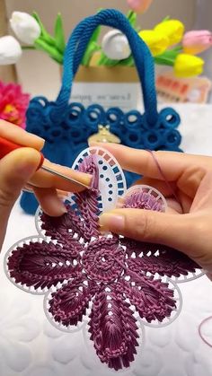 a woman is working on a piece of crochet