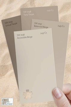 a hand holding three different shades of paint on sand with the words, neutral taupe