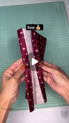 someone is cutting out an origami bow with scissors