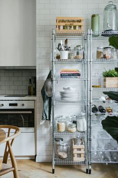 an organized kitchen with shelves, pots and pans