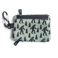 The important thing is that you believe in yourself! Bigfoot sure does. He marches proudly across this pattern with Fir Trees behind him on a sage green canvas. This two-sided little wallet is just what you need to keep it light and carefree. Two zipper pockets on opposite sides to hold your change, cards or keys. There is also a small zipper pocket on the inside. The included S-Biner clip will make for quick clipping to a bag or your belt loop. Easily slips in your back or front pocket for fast Green Zipper Pouch Wallet For Travel, Green Wallet With Zipper Pocket For Everyday Use, Green Travel Wallet With Zipper Pouch, Green Wallet With Zipper Pouch For Personal Use, Casual Green Coin Purse For Daily Use, Casual Green Wallets For Everyday Use, Casual Green Wallet For Everyday Use, Casual Green Wallet With Zipper Closure, Fir Trees