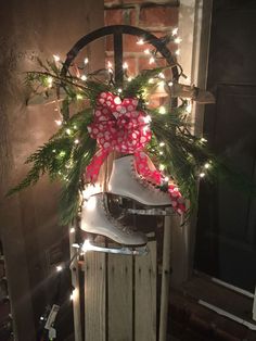 a pair of roller skates decorated with christmas lights and bows sitting on top of a wooden crate