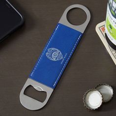 a bottle opener sitting on top of a table next to a cell phone and money