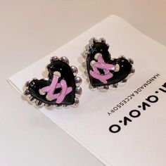 Elevate your style with our Pastel Goth Corset Heart Earrings. These metal earrings feature a heart-shaped design with corset ribbon details, perfect for a cute, cool, and unique aesthetic. Pastel goth aesthetic Heart shaped design Corset ribbon details on heart Metal Package: 1 pair of earrings Silver Emo Earrings For Parties, Emo Metal Earrings For Parties, Emo Style Metal Earrings For Party, Black Metal Heart Charm Earrings, Black Metal Earrings With Heart Charm, Cute Black Party Earrings, Gothic Black Heart-shaped Earrings, Trendy Double Heart Earrings For Party, Punk Heart-shaped Earrings