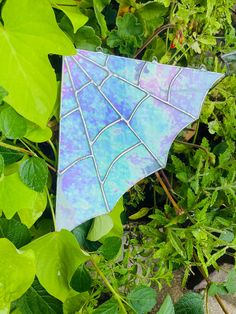 a blue umbrella sitting on top of green leaves