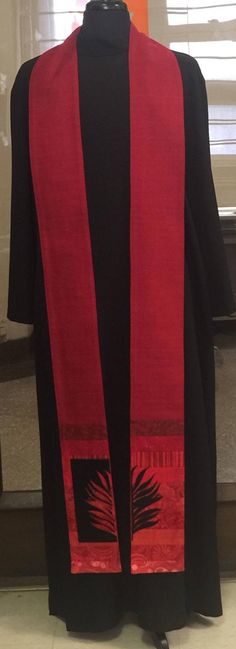 a red and black robe on display in front of a window