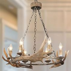 a chandelier with deer antlers hanging from it's sides and lights on each side