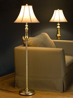 a living room with a couch and two lamps on the table next to each other