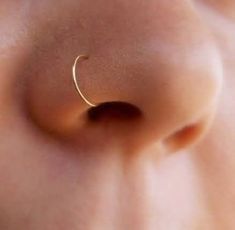 a close up view of the side of a baby's tummy with a gold nose ring