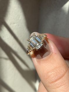 In total, this art deco-inspired emerald engagement ring has a total of 9 diamonds– sporting full finger coverage with one center 1.97 emerald and four baguettes on either side.⁠ Emerald White Gold Engagement Ring, Emerald Cut Stacked Wedding Rings, Emerald Cut With Baguettes, Frank Darling, Wedding Rings Emerald Cut, Art Deco Wedding Ring, Baguette Engagement Ring