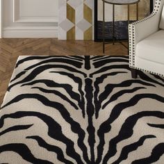 a black and white zebra print rug in the middle of a room with a chair