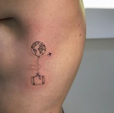 a woman's stomach with a small tattoo of a balloon flying over the earth