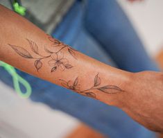 a man with a flower tattoo on his arm and wrist is holding a pair of scissors