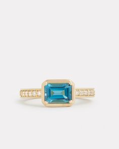 18K Yellow Gold Emerald Cut London Blue Topaz Ring with Diamonds, .21 TCW Ornament is 3/8 Inch x 1/4 Inch Style# YRHECLBTW Emerald Cut Aquamarine Ring, London Blue Topaz Ring, Aquamarine Rings, Bracelet Collection, Blue Topaz Ring, London Blue Topaz, London Blue, Topaz Ring, Pink Tourmaline