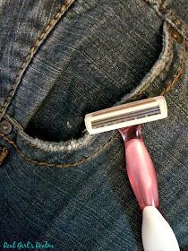 a pink and white brush sticking out of the back pocket of a pair of jeans