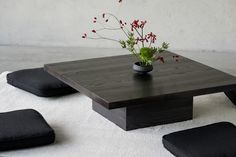 a wooden table with flowers in a vase on top