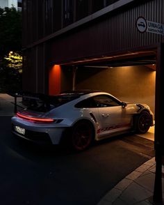 a white sports car parked in front of a building