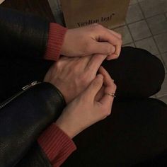 two hands holding each other over a book