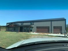 a car is parked in front of a large house with two garages on it