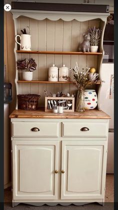 an old dresser is decorated with vases and other things on it's shelves