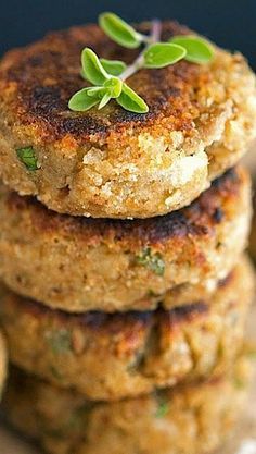 three crab cakes stacked on top of each other with a sprig of green