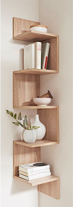 three wooden shelves with books and vases on them