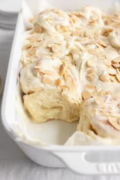 a close up of a casserole dish with almonds on top and white icing