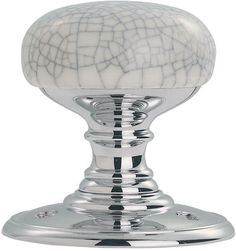 a white marble knob on a chrome plated metal stand with an intricate design and polished finish