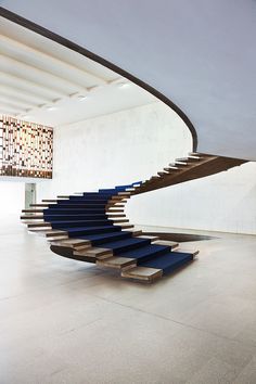 a spiral staircase made out of wood and blue carpet