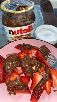 chocolate covered strawberries on a pink plate next to nutella