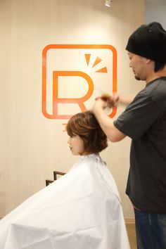 the man is cutting the woman's hair in the salon