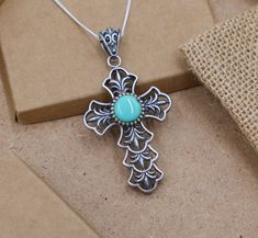 This stunning 11.5 gram silver cross pendant is a bold statement piece featuring a beautifully placed round turquoise stone at its center. The intricate design of the cross adds a touch of elegance and reverence, making it an exceptional choice for anyone who values both style and symbolic significance. Material: 925 Sterling Silver Weight: 11.5 grams Dimensions: 5 cm x 3 cm Center Stone: Turquoise Chain Length: 18 inches Design: Detailed cross design with a central turquoise stone that highligh Spiritual Turquoise Necklace With Cross Pendant Gift, Spiritual Turquoise Cross Pendant Necklace Gift, Spiritual Cross Turquoise Necklace For Gift, Spiritual Turquoise Cross Necklace As Gift, Spiritual Turquoise Cross Necklace, Spiritual Turquoise Cross Necklace For Gift, Handmade Turquoise Cross Pendant Necklace, Turquoise Cross Sterling Silver Necklace, Turquoise Sterling Silver Cross Necklace